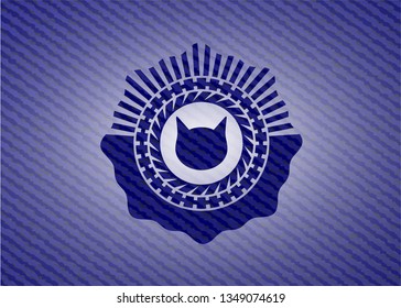 cat face icon inside badge with denim texture