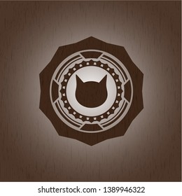 cat face icon inside badge with wood background