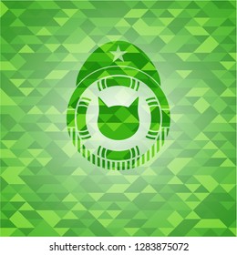 cat face icon inside green emblem. Mosaic background