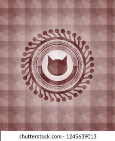 cat face icon inside red seamless emblem or badge with geometric pattern background.