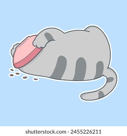 cat is laying on the ground with a pink bowl in its mouth