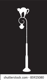 Cat stretching on the street lamp silhouette