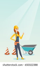 Caucasian builder showing thumb up while standing near wheelbarrow. Young builder in hard hat giving thumb up. Builder at work on construction site. Vector flat design illustration. Vertical layout.