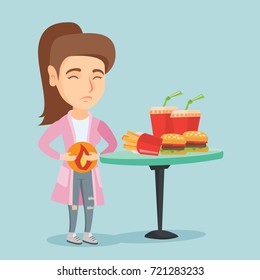 Caucasian sad woman standing near the table with fast food and having a stomach ache from heartburn. Young woman suffering from a heartburn after fast food. Vector cartoon illustration. Square layout.