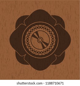 CD or DVD disc icon inside badge with wood background
