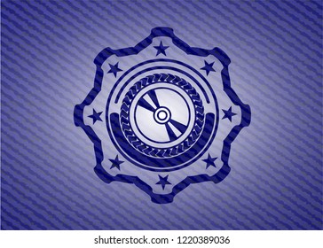 CD or DVD disc icon inside emblem with jean texture