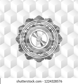 CD or DVD disc icon inside realistic grey emblem with geometric cube white background