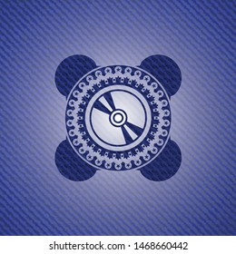 CD or DVD disc icon inside emblem with denim texture