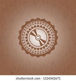 CD or DVD disc icon inside badge with wood background
