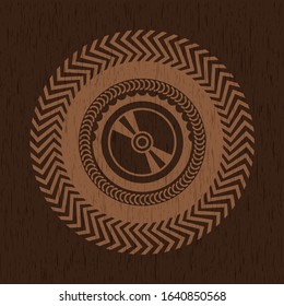 CD or DVD disc icon inside badge with wood background