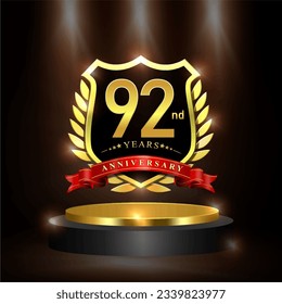 Celebrating 92 years anniversary logo with golden shield and ribbon, laurel wreath, cylinder podium vector design.