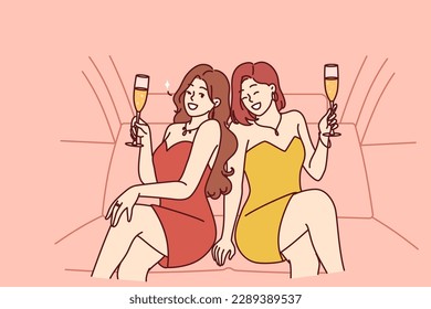 Celebrity women sit in luxury car with glasses filled with sparkling wine during pre-wedding bachelorette party. Celebrity girls in evening dresses riding in limousine enjoy premium atmosphere 