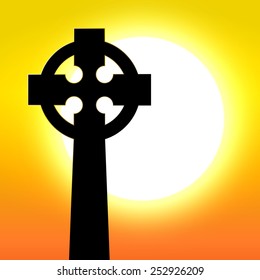 Celtic cross in front of sunset