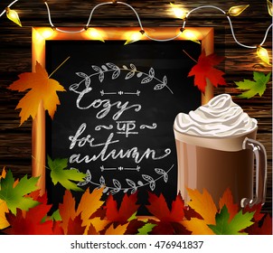Chalkboard with autumn leaves and cup Hot chocolate and cozy patio lights