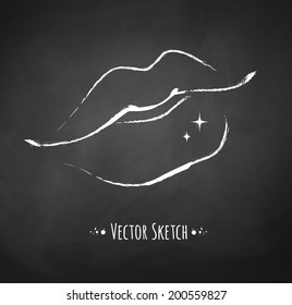 Chalked sketch of female lips on blackboard background. 