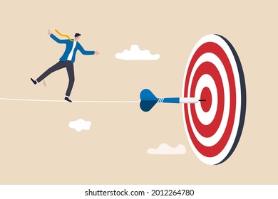 Challenge to overcome difficulty and achieve business target, risk management or strategy and skill to win and success concept, skillful businessman acrobat walk on rope to reach bullseye dart target.