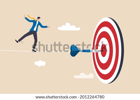 Challenge to overcome difficulty and achieve business target, risk management or strategy and skill to win and success concept, skillful businessman acrobat walk on rope to reach bullseye dart target.