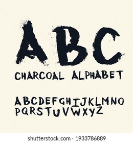 Charcoal handwritten alphabet. On textured paper with crumbling particles.