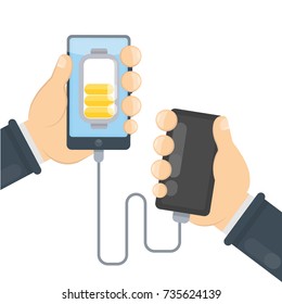 Charging phone with power bank. Hands holding devices.