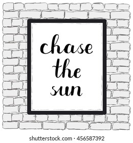 Chase the sun. Brush hand lettering on a sample poster hanging on a brick wall. Great for photo overlays, posters, apparel design, holiday clothes, cards and more.