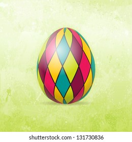 Checkered Easter egg in bright colors on distressed background in shades of light to dark spring green.