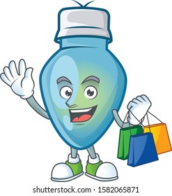 Cheerful blue christmas bulb cartoon character waving and holding Shopping bags