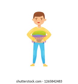 Cheerful boy holding small laundry basket with clean folded clothes. Housework and chores theme. Flat vector illustration
