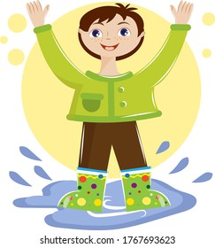 A cheerful boy jumps in puddles after the rain. The boy is having fun and smiling.