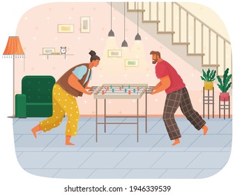 Cheerful couple with board game. Man and woman play table football together in room near stairs
