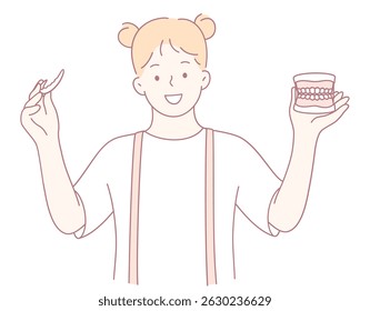 A cheerful girl holds a toothbrush with a dental model, promoting good dental hygiene habits for all