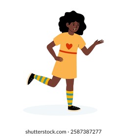 Cheerful girl in a yellow dress with heart design and striped socks waving happily