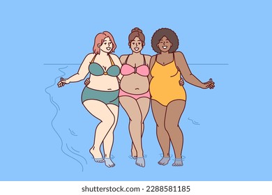 Cheerful plus size women dressed in swimsuit stand hugging on sunny beach near sea water and look at camera smiling. Diverse plus size girls for concept of no prejudice and body positivity