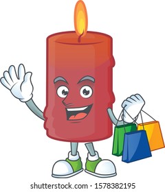 Cheerful red candle cartoon character waving and holding Shopping bags