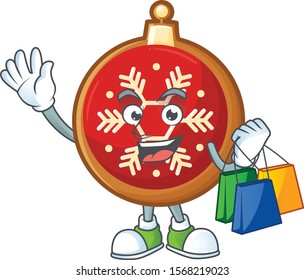 Cheerful red christmas ball cartoon character waving and holding shopping bag.