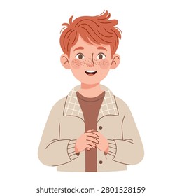 Cheerful redhaired boy in a beige jacket holding a red heartshaped object with a smile