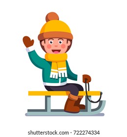 Cheerful smiling boy kid sitting on sled in winter outdoors. Little child enjoying sledding and waving his hand in a welcoming gesture. Flat style vector illustration isolated on white background.