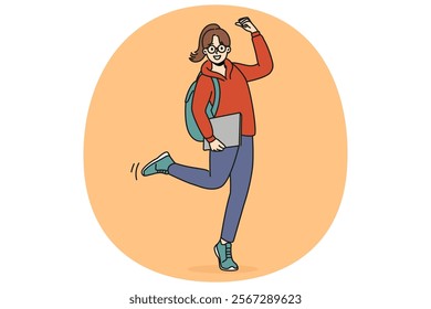 Cheerful student girl makes victory gesture and holds books in hands, rejoicing at receiving quality education. Young woman student with backpack smiling celebrating entering college or university