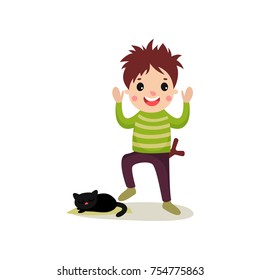 Cheerful teenager going to step on cat s tail, bad boy behavior concept