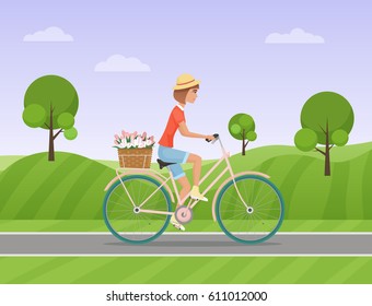 Cheerful woman with flowers in the basket riding a bike on a park road. Vector illustration.