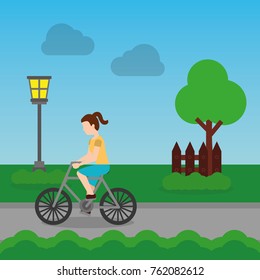 cheerful woman riding a bike on a park road