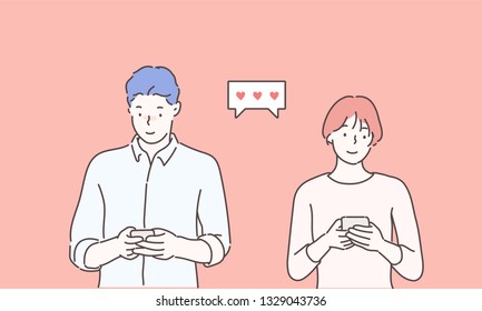 Cheerful young couple standing isolated over pink background, holding smart phones in casual wear.Hand drawn style vector design illustrations.