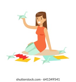 Cheerful young woman making origami cranes from colorful papper. Craft hobby and profession colorful character vector Illustration