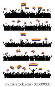 Cheering or protesting LGBT people waving rainbow flags and holding posters. Crowd at an event against homophobia and transphobia.