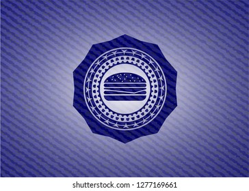 cheeseburger icon inside badge with denim texture