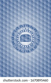 icono del cheeseburger dentro del emblema azul con un patrón geométrico.