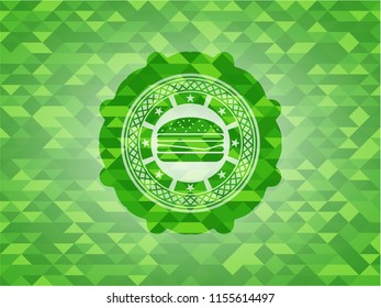 cheeseburger icon inside green emblem. Mosaic background