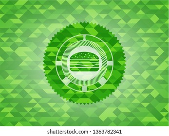 cheeseburger icon inside green emblem with triangle mosaic background