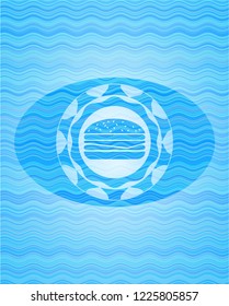 cheeseburger icon inside light blue water style emblem.