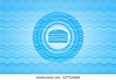 cheeseburger icon inside light blue water wave emblem.