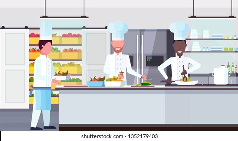 chef cook carrying plate with meal ingredients mix race workers cooking food culinary teamwork concept modern commercial restaurant kitchen interior horizontal flat